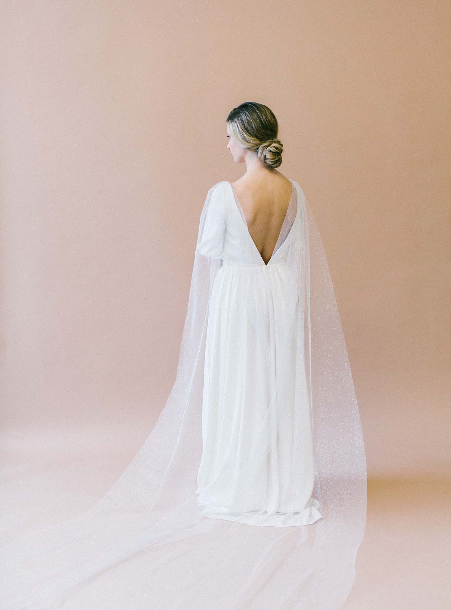 Draped shimmer bridal cape attached to wedding gown